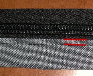 Side zipper seams from the outside, indicated in red.  Notice first seam is inside the fold and second seam secures the fold.
