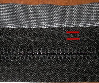 Side zipper seams from the inside, indicated in red.  Notice the fabric just sticking out past the zipper from the first seam, before the fold.